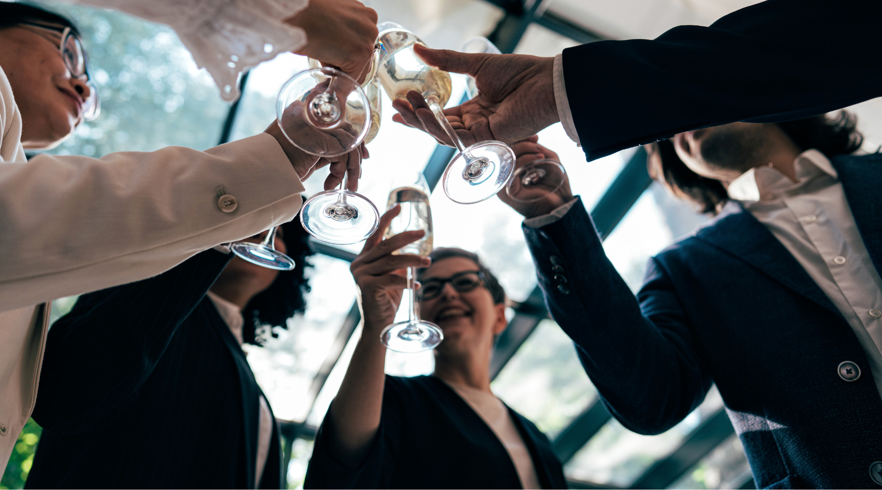 A diverse group of professionals toasting with champagne glasses at a corporate holiday celebration, symbolizing successful event planning and teamwork.