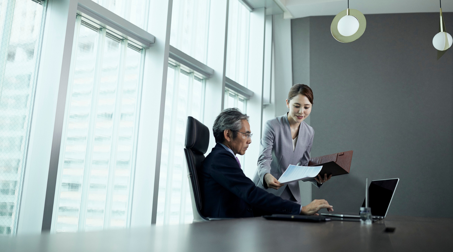 Executive assistant providing paperwork for the executive.