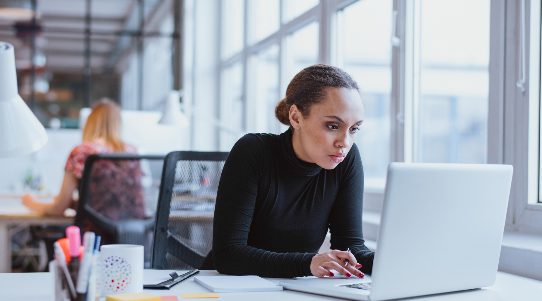 Image of an executive assitant working at laptop.